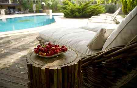 Sonnenliege am Pool mit Früchten auf einem Tischchen zum Genießen, hier reich werden
