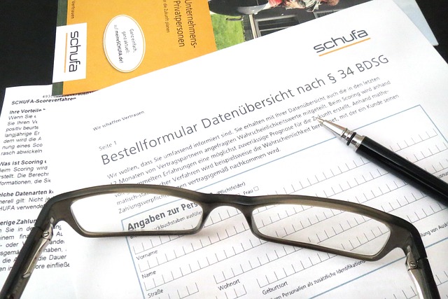 Brille auf Formular zur Schufa Auskunft mit Kugelschreiber, hier Bonität prüfen