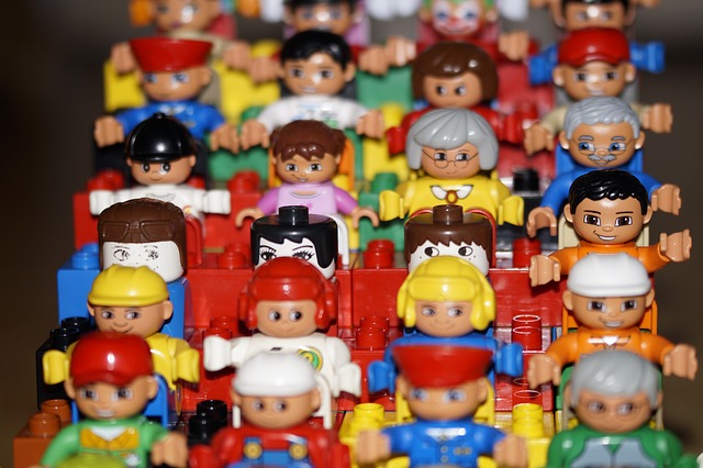 Viele kleine Legomännchen stehen in einer Reihe nebeneinander und voreinander. Hier: Crowdinvesting und Crowdfunding