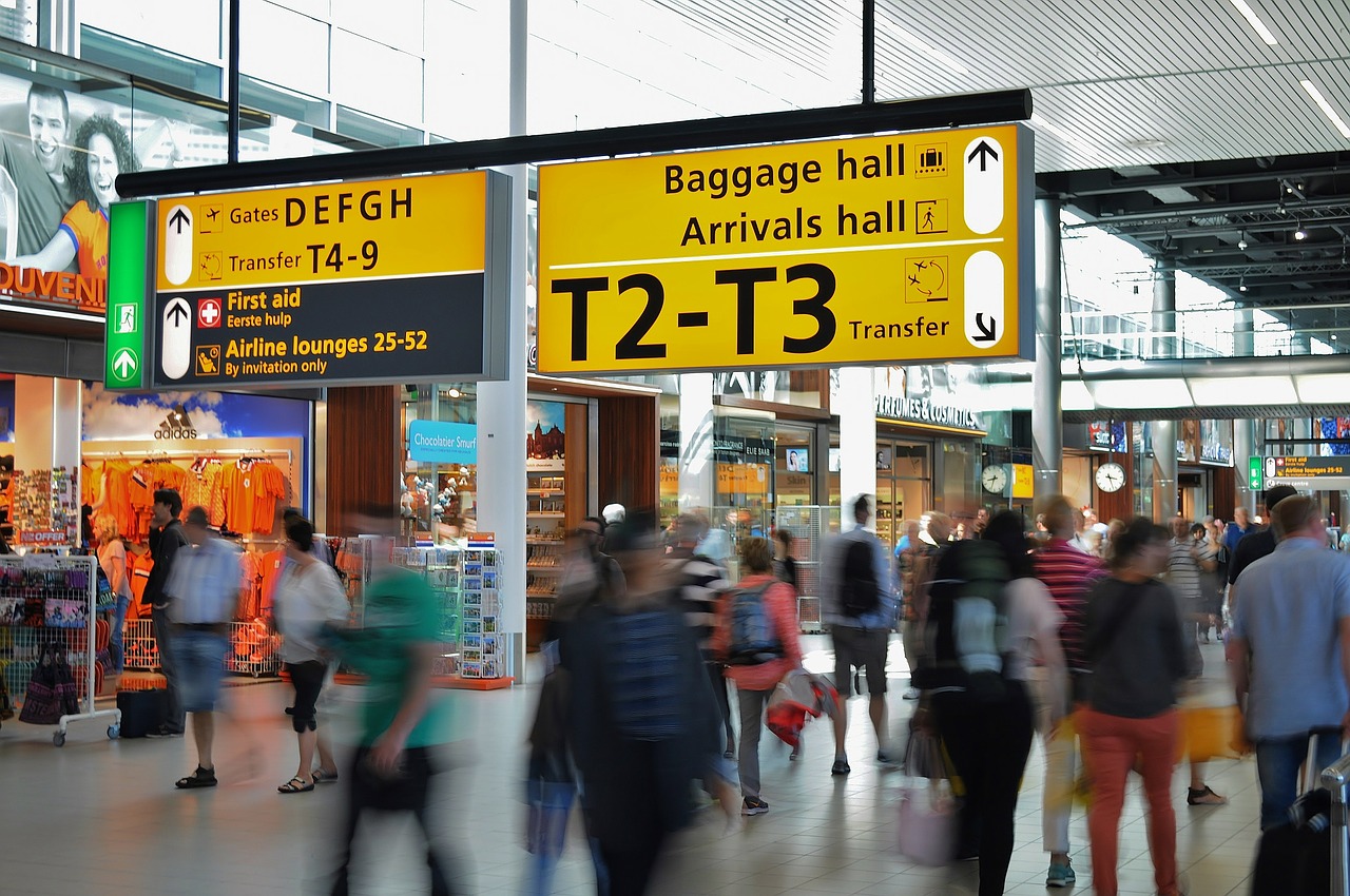 Am Flughafen, viele Leute rennen ganz geschwind durcheinander, hier: häufige Fragen zu den Ladenöffnungszeiten