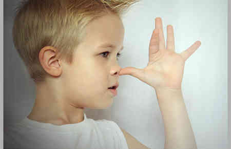 Kind zeigt einem eine lange Nase, indem es dem Daumen auf die Nase setzt und die anderen Finger nach oben abspreizt. Hier Schlagfertigkeit Frechheit.